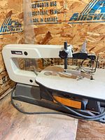 Full view of Makita scroll saw showing body, table, dust hose, power cord