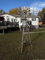 Full view of metal garden windmill standing on lawn