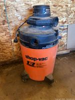 Full view of Shop-Vac showing drum, motor housing and casters