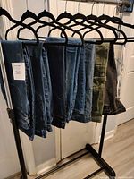 Eight pairs of jeans hanging on rack