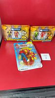 All three sealed action figure sets on red backdrop