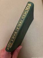 Spine view showing green cloth cover, gilt title and decorative motif