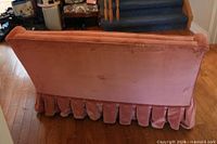 Rear view showing pink velvet upholstery and pleated skirt