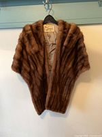 Front view of mink stole on hanger showing overall shape, color and pelting