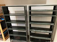 Front view of both metal shelving units showing six shelves each