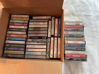 Open box with majority of cassette tapes plus additional stack on right