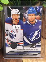 Front of 2023-24 Upper Deck Series 1 checklist card with McDavid and Stamkos, sticker residue visible