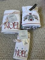 All three towel sets, two NOEL rolls and one Aphorism fold, ribbon wrapped with tags
