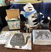 Overview of all items: Coco Dowley cat teapot, boxed cat shakers, two cat figurines, three napkin packs