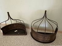 Pair of bronze-tone tin wall shelves on carpeted floor
