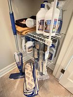 Closet view showing spray mop, polish bottles, cleaner bottles, pad pack, handle parts