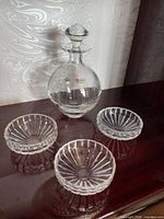 Full view of decanter with stopper and three bowls on surface