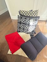 Group shot showing pillows, red shams, off-white throw and navy Hobbii cushion