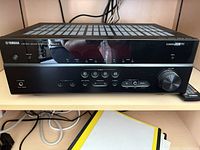 Front view of Yamaha RX-V575 receiver and remote on shelf