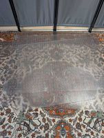 Three clear frosted vinyl chair mats layered on patterned rug