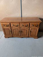 Full front view of oak sideboard showing overall design, drawers, doors, and hardware