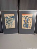 Both framed woodblock prints standing side by side