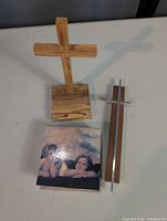 Overall view of wooden freestanding cross, cherub panel, and metal-inlay cross
