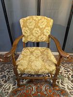 Front view of armchair showing wood frame and floral upholstery