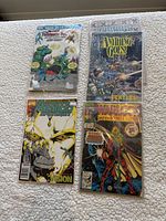 Four bagged comic books laid out showing covers