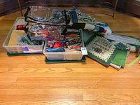 Two clear plastic bins, mesh tote bag, folded fabric panels and scraps grouped on floor
