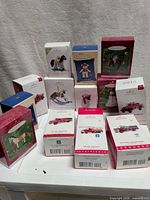Group shot of all 13 Hallmark ornament boxes stacked on table