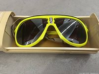 Front view of neon yellow Carrera Glacier sunglasses in beige case