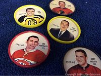 Lot of five vintage Sheriff hockey coins from 1962-63 with player portraits including Lou Fontinato, Don Ward, Phil Watson, and Jerry Melnyk on blue carpet background.