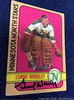 Front view of vintage 1972-73 O-Pee-Chee Minnesota North Stars hockey card featuring Lorne Worsley in goalie gear against pink background, showing full card and autograph.