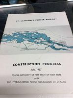Front cover photo showing title and map illustration of the St Lawrence Power Project area with construction progress details from July 1957.