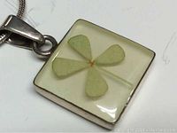 Close-up of the pendant front showing four leaf clover under resin.