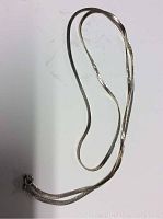 Full view of silver herringbone necklace showing length and clasp