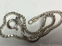 Close-up photo displaying the silver box chain and the spring ring clasp of the bracelet