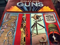 Front cover of the vintage coffee table hardcover book titled 'Guns' by Dudley Pope, showing illustrated images of historical guns and weaponry.
