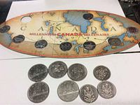 Canada Millennium display board dated 1999 holding various Canadian coins including dollar, half dollar, and quarter denominations.