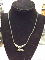 Photo of necklace on black display stand showing overall piece length and pendant placement.