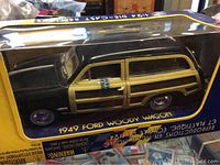 Side view of 1949 Ford Woody Wagon 1/24 scale die-cast model in original box showing wood panel details along side and black body.