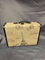 Front of suitcase showing map graphics, trim and handle