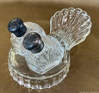 Full view of shakers seated in pressed glass tray