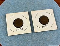 Both cardboard-housed coins side by side