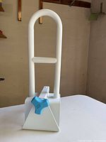 Front view of white adjustable bathtub grab bar showing U-shaped handle and blue knob