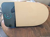 Top view of Horow T38 smart toilet seat showing black glass control panel with illuminated LEDs and beige protective film