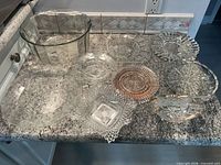 Group shot of all nine glass serveware pieces on countertop