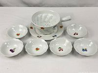 entire 8-piece set displayed: colander on plate, six bowls