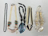 All five necklaces laid out side by side