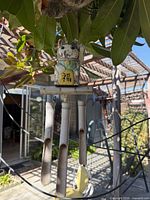 Overall view of wind chime with cat figure and four metal tubes