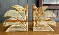 Front view of both onyx bookends showing fleur-de-lys carving and banded colors