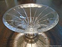 Clear glass serving dish with a wide flared rim and vertical ribbed pattern.