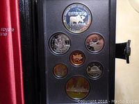 Coins displayed in the presentation case showing seven proof coins including the silver double dollar featuring a moose and Canadian National Parks Centennial design.