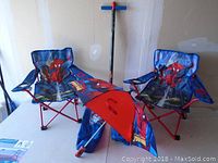 Photo showing two Spider-Man foldable kids chairs and one umbrella.